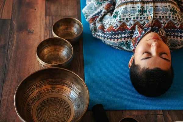 Yukarıdan kız Tibet şarkı kasesinde meditasyon yapıyor.