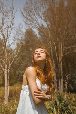 Kızıl saçlı bir kızın portresi çiçekler, yaşam tarzı, bahar konsepti