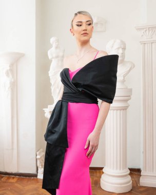 Bir manken siyah pembe bir elbise giyer. 