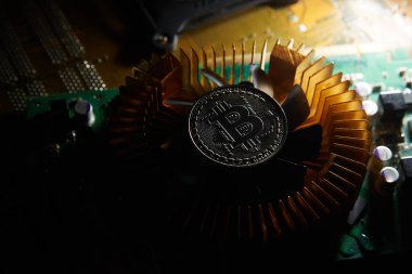 Üzerinde bitcoin olan bir fan bilgisayar çipinde oturuyor.