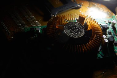 Üzerinde bitcoin olan bir fan bilgisayar çipinde oturuyor.