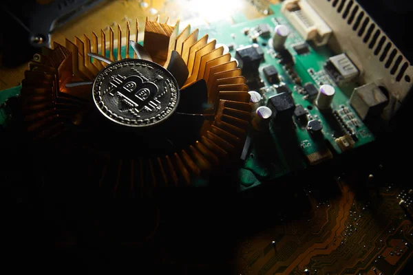 Üzerinde bitcoin olan bir fan bilgisayar çipinde oturuyor.