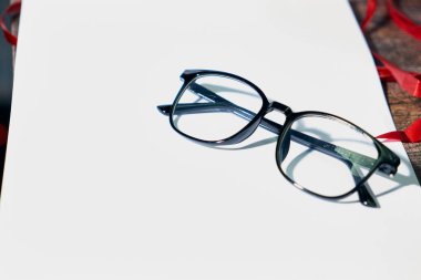 Beyaz kağıt üzerinde siyah optik gözlük
