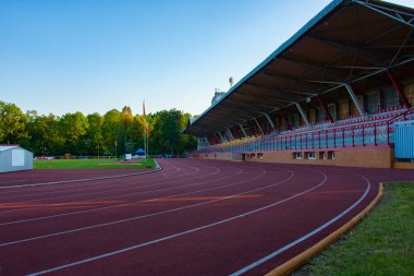 Spor stadyumu, açık hava stadyumunda koşucular için belirlenmiş kırmızı bir koşu bandı, taraftarlar için, Polonya, Bialystok