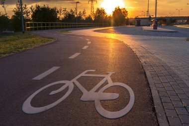 Şehirde bir bisiklet yolu bir sembol ile işaretlenmiş, batan güneş bisiklet işaretini aydınlatıyor.