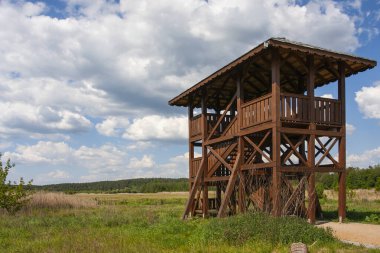 Kırsal çayır manzaralı bir gözetleme kulesi ve nehrin kıyısında bir eğitim yolu. Polonya, Podlasie, Suprasl