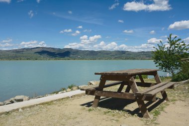 Trasimeno gölü yakınlarında piknik masası. Güneşli bir günde birlikte yemek yemek için masa. Arka planda Trasimeno Gölü. Umbria