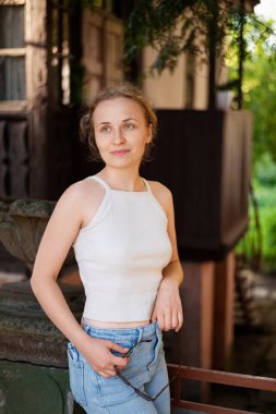 Beyaz bluz ve kot giyen kızıl saçlı genç bir kız.