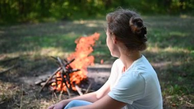 Şenlik ateşine bakan bir kadın. 