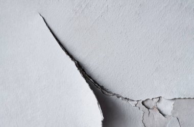 Çimento duvar arkaplanı, çatlamış beyaz boya, kırılmış beton yüzey.