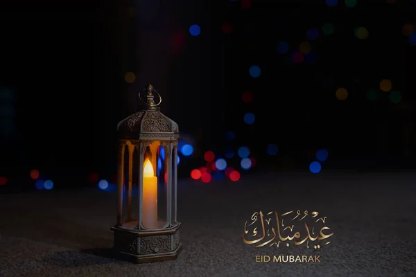 Eid Mubarak calligraphy greeting design with islamic Lantern on carpet with blurry light background. Religion of Muslim Symbolic,Eid ul fitr,Eid al Adha,Eid el kabir,Islamic new year Muharram