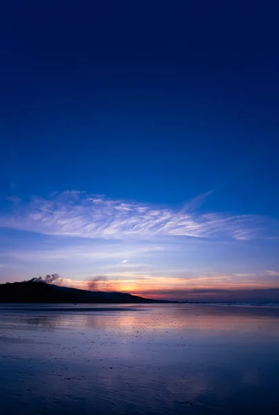 夕阳西下的天空 晚霞笼罩在沙滩上的云彩 艳丽的自然海滨风景 蓝色的天空 夏日阳光反射在沙滩上的垂直黄昏天空 — 图库照片