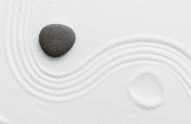 Japon bahçesindeki Zen Taşı, beyaz kum desenli gri kaya deniz taşı arka planda, Yin ve Yang antik Çin felsefesinde ikiliğin sembolü. Uyum, meditasyon, Zen gibi kavramlar.