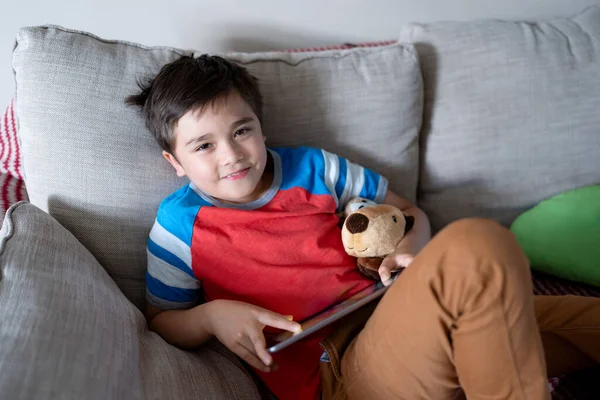 stock image Preteen schoolboy doing homework with digital tablet in living room,Child using gadgets to study. Kid learns online from home,Education learning with new technology for kids.