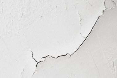 Duvarda beyaz kabuk soyma boyası çatlamış Flaking Alçı boyalı eski gri beton duvar. Zemin Çimento Yıpranmış Sert Boyalı Yüzey Çatlaklar ve soyulma desenleriyle