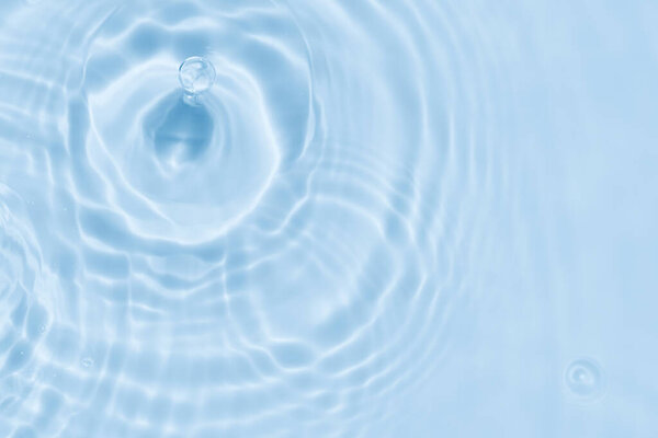 Water background. Blue water surface texture with ripple waves with sunlight reflection,Blurred transparent clear blue calm water with splashes and bubbles.Beautiful abstract nature background.