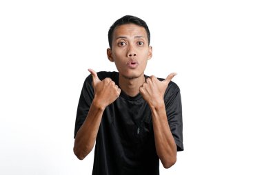 asian man wearing black training t-shirt, feeling happy and giving thumbs up. Isolated by white background