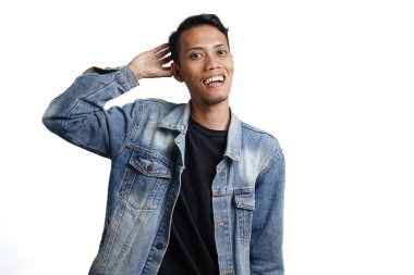 Asian man wearing stylish blue jean jacket holding head, because it's cool. Isolated by white background