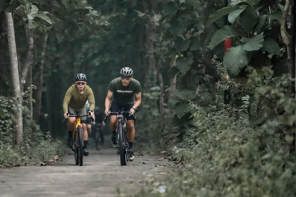Cyclist Helmet Rides Bicycle Country Road Using Gravel Bike Uphill 免版税图库图片