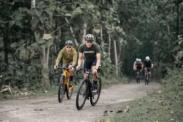 헬멧을 사이클 리스트는 자전거를 시골길을 갑니다 언덕을 오르기 자전거를 이용하는 스톡 사진