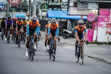 A group of road bike cyclists passed an interesting route in Yogyakarta, in preparation for the Tour de Ambarrukmo. : Yogyakarta - Indonesia, February 11, 2022