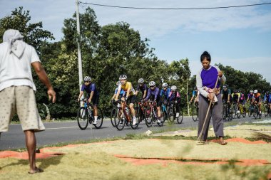 A group of road bike cyclists passed an interesting route in Yogyakarta, in preparation for the Tour de Ambarrukmo. : Yogyakarta - Indonesia, February 11, 2022