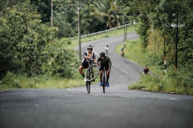 The road bike is going uphill on the cool route of the incline in Panggang area, very aesthetic. Requires great power. : Yogyakarta - Indonesia, February 11, 2022
