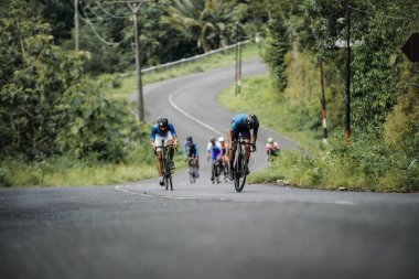 The road bike is going uphill on the cool route of the incline in Panggang area, very aesthetic. Requires great power. : Yogyakarta - Indonesia, February 11, 2022