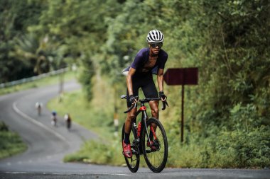 The road bike is going uphill on the cool route of the incline in Panggang area, very aesthetic. Requires great power. : Yogyakarta - Indonesia, February 11, 2022