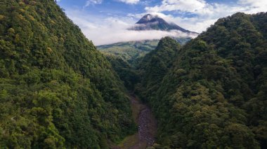 Beautiful morning view of Mount Merapi in Yogyakarta, Indonesia. Squished hills and shrouded in clouds.