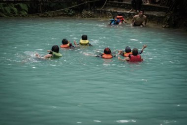 Visitors who swim enjoy the natural attractions of Kedung Pedut, a beautiful natural swimming pool tour. : Kulon progo, Indonesia - 04 May 2022