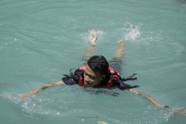 tourists enjoying a natural swimming pool, at the tourist spot Kedung Pedut, Yogyakarta, Indonesia. The unique and fresh river is blue