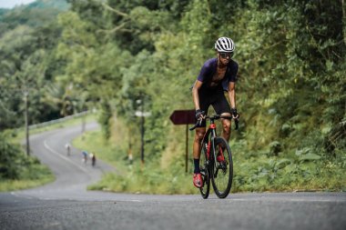 The road bike is going uphill on the cool route of the incline in Panggang area, very aesthetic. Requires great power. : Yogyakarta - Indonesia, February 11, 2022