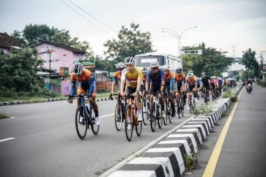 A group of road bike cyclists passed an interesting route in Yogyakarta, in preparation for the Tour de Ambarrukmo. : Yogyakarta - Indonesia, February 11, 2022
