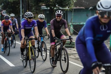 A group of road bike cyclists passed an interesting route in Yogyakarta, in preparation for the Tour de Ambarrukmo. : Yogyakarta - Indonesia, February 11, 2022