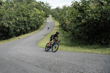 Roadbike riders speed through epic routes in jungle areas. : Yogyakarta - Indonesia, February 11, 2022