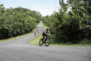 Roadbike riders speed through epic routes in jungle areas. : Yogyakarta - Indonesia, February 11, 2022