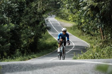 Roadbike riders speed through epic routes in jungle areas. : Yogyakarta - Indonesia, February 11, 2022