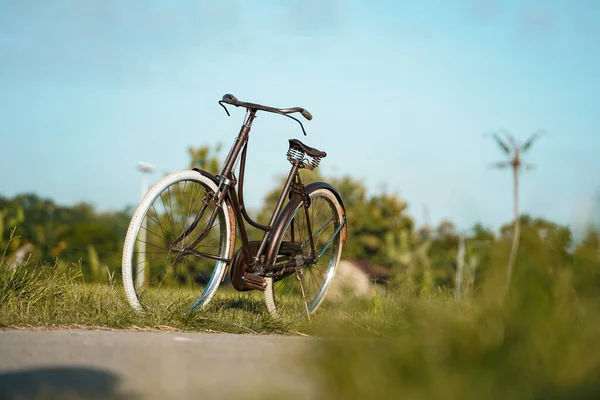 田んぼの周りの村道に展示されている古典的なオネル自転車 — ストック写真