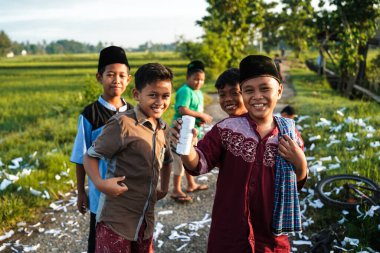 Yogyakarta, Endonezya - 16 Nisan 2023: Bazı çocuklar sabah namazından eve dönerken, Ramazan ayı boyunca köyün sokaklarında havai fişek atarken hala Müslüman gibi görünüyorlar