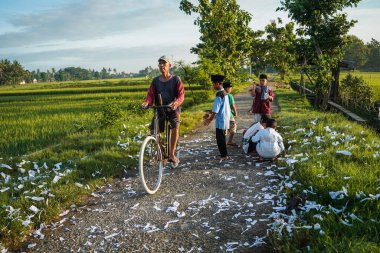 Yogyakarta, Endonezya - 16 Nisan 2023: Bazı çocuklar sabah namazından eve dönerken, Ramazan ayı boyunca köyün sokaklarında havai fişek atarken hala Müslüman gibi görünüyorlar