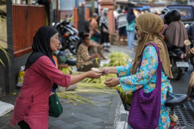 Alıcı ve satıcı anlaşmasının süreci, yolun ucunda Ketupat satmak. Bayram hazırlıkları için. : Yogyakarta, Endonezya - 20 Nisan 2023