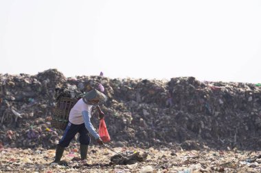 Piyungan 'ın son atık sahasında birikmiş büyük çöp dağları çöpçülerin onları topladığı görülebilir. Yogyakarta 'da atık yönetimi acil durumu.