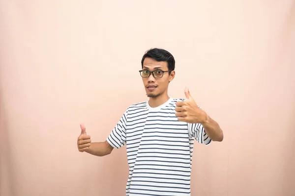カジュアルなストライプのシャツを着たアジアの男性は 親指をジェスチャーに与えるか それに同意します 隔離されたベージュの背景 — ストック写真