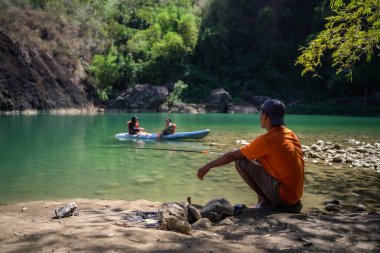 Uçurum manzaralı temiz bir nehrin kenarında balık tutmak. : Bantul, Endonezya - 27 Temmuz 2023