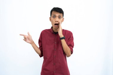 Asyalı bir adam, iş adamı ya da öğrenci konsepti, kırmızı günlük bir gömlek giyiyor, yan tarafları gösteriyor, el ele fısıldıyor, bilgi veriyor, beyaz arka planda izole edilmiş..