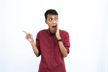 Asyalı bir adam, iş adamı ya da öğrenci konsepti, kırmızı günlük bir gömlek giyiyor, yan tarafları gösteriyor, el ele fısıldıyor, bilgi veriyor, beyaz arka planda izole edilmiş..