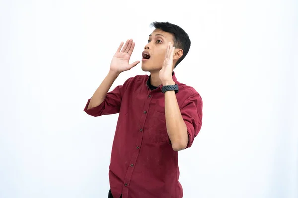 stock image Asian man, businessman or student concept wearing red casual shirt, shouting with hand in mouth, giving information or whispering, isolated on white background.