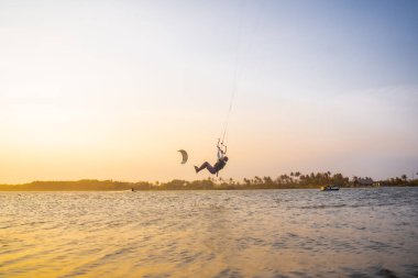 Uçurtma. Bir sörfçü güzel köprüler ve kıyı şeritlerine karşı at sürüyor ve her türlü gösteriyi sergiliyor. Spor, sağlık, eğlence konsepti. : Yogyakarta, Endonezya - 26 Ağustos 2023