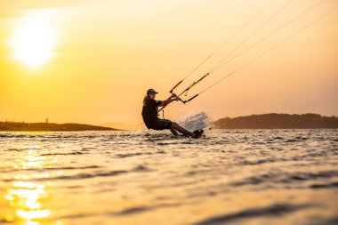 Uçurtma. Bir sörfçü gün batımında güzel bir köprü ve sahil şeridinde sörf yapar ve her türlü gösteriyi sergiler. : Yogyakarta, Endonezya - 26 Ağustos 2023